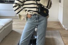 a comfortable fall outfit with a black and white stripe sweater, blue mom jeans, grey sneakers and a black bag