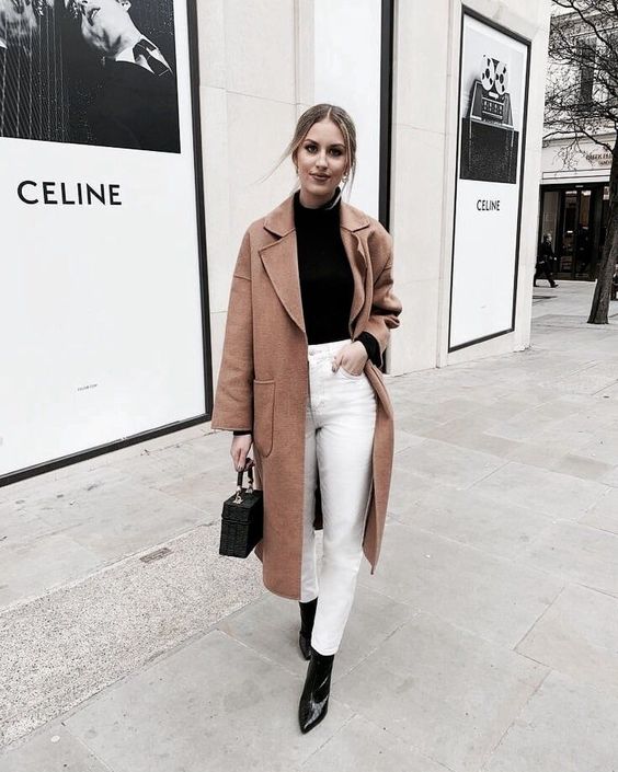 a contrasting fall look with a black turtleneck, boots and a box bag, a beige coat and white mom jeans