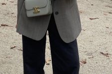 a fall work outfit with a white t-shirt, black trousers, black chunky loafers, an oversized grey blazer and a matching grey bag