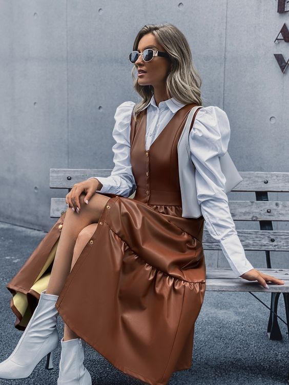a feminine outfit with a white blouse and puff sleeves, a brown midi pinafore dress, white sock boots for a girlish person