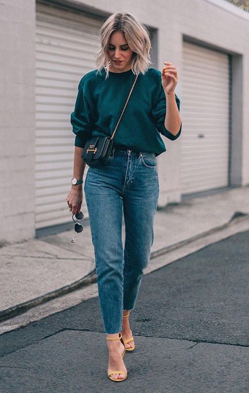 a green sweatshirt, blue mom jeans, nude heeled sandals and a black mini bag are great for the fall