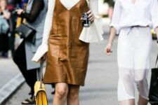 a lovely outfit with a white shirt with bell sleeves, a brown slip leather dress, red mules and a yellow bag for the fall