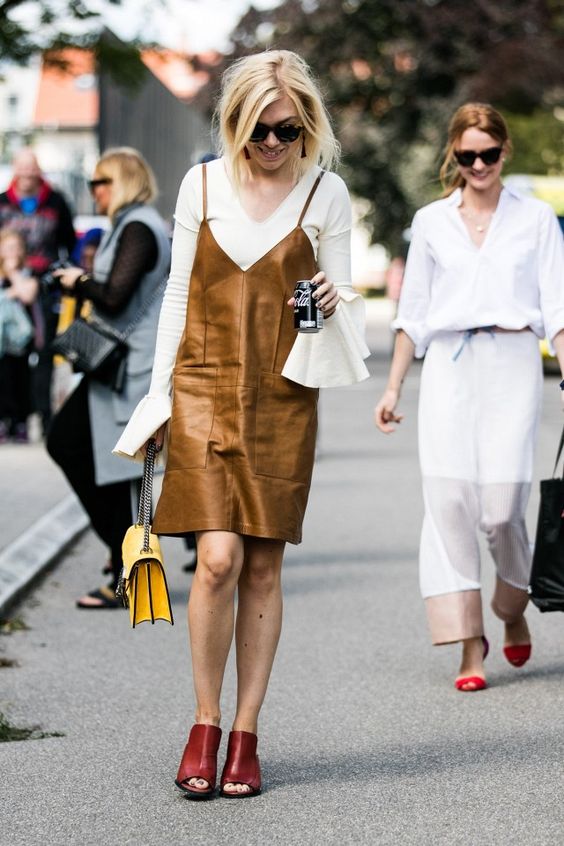 a lovely outfit with a white shirt with bell sleeves, a brown slip leather dress, red mules and a yellow bag for the fall