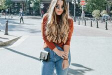 a pretty and lovely fall look with a rust-colored turtleneck, blue mom jeans, brown shoes and a black bag