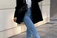 a stylish and contrasting fall work outfit with a white hoodie, blue high waisted jeans, black and white trainers, a black blazer and a black bag