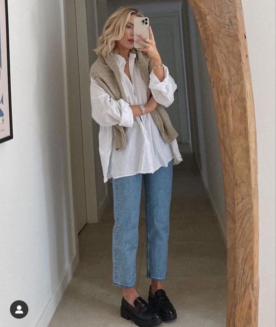 a white oversized shirt, blue cropped jeans,a  tan sweater over the shoulders and black chunky loafers to rock in the fall