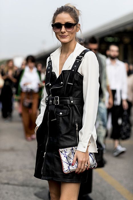 a white shirt, a black leather overall dress in rock style and a metallic clutch compose a lovely rock look