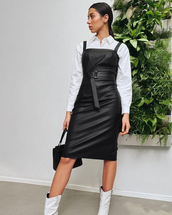 a white shirt, a black pinafore midi leather dress, white cowboy boots and a black bag are a cool combo for the fall