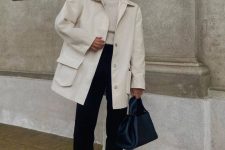 an elegant fall outfit with a white turtleneck, black trousers, a creamy shirt jacket, black chunky loafers and a navy bag
