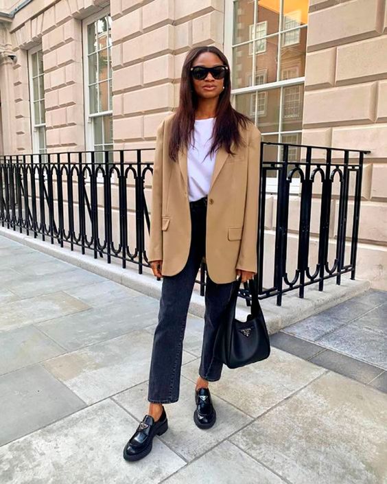 an elegant work outfit with a white t-shirt, black cropped jeans, a tan oversized blazer, black chunky loafers and a black bag