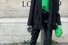 an emerald turtleneck and woven bag, black leather trousers, a black oversized blazer and black chunky loafers