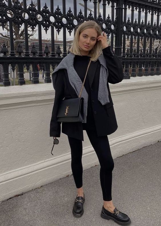 black leggings, a black top and blazer, loafers and a bag plus a grey sweater over the shoulders for a touch of freshness