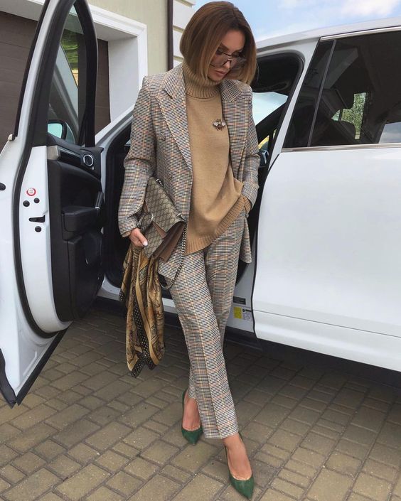 a grey and pink plaid suit, a beige turtleneck, green shoes, a printed bag are a great combo for work