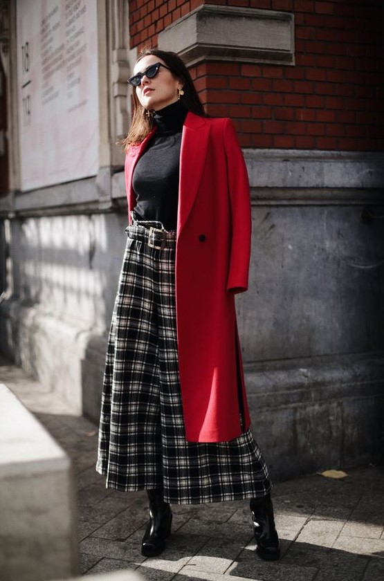 a chic outfit with a blakc turtleneck, plaid culottes, black shoes and a red coat is style and classics
