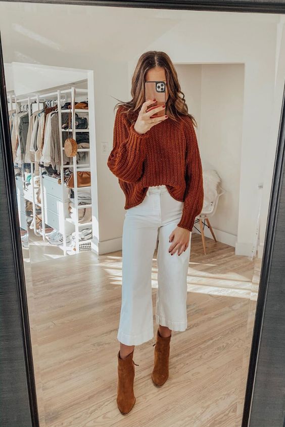 an easy Thanksgiving look with a burnt orange chunky knit sweater, white cropped jeans, brown boots