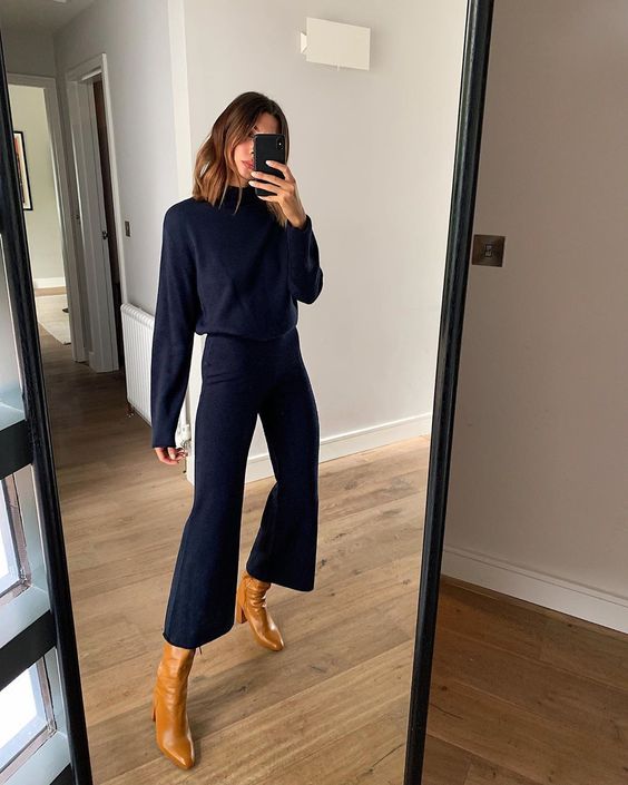 a beautiful Thanksgiving outfit with a navy turtleneck and cropped flare pants, amber-colored leather boots