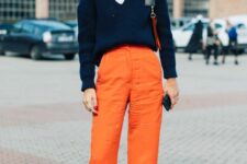 23 a cute and chic Thanksgiving outfit with a white button up top, a navy pullover, orange pants, grey shoes
