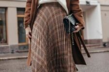 24 a white sweater, a brown plaid pleated midi, black boots, a black bag and a brown coat