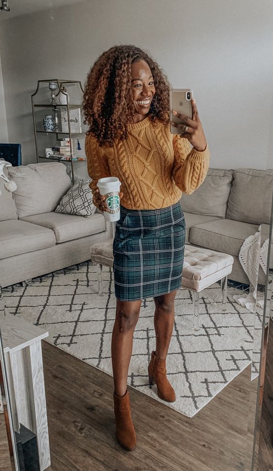 a yellow patterned sweater, a navy and green plaid skirt, brown boots are a cool fall work look