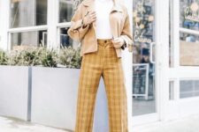 29 a white turtleneck, mustard plaid trousers, a tan jacket, white boots and a creamy hat