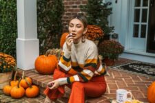 31 orange leather pants, a grey sweater with bold fall-colored stripes and tan sock boots for any kind of Thanksgiving event