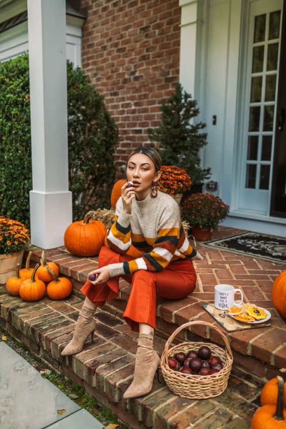 orange leather pants, a grey sweater with bold fall-colored stripes and tan sock boots for any kind of Thanksgiving event