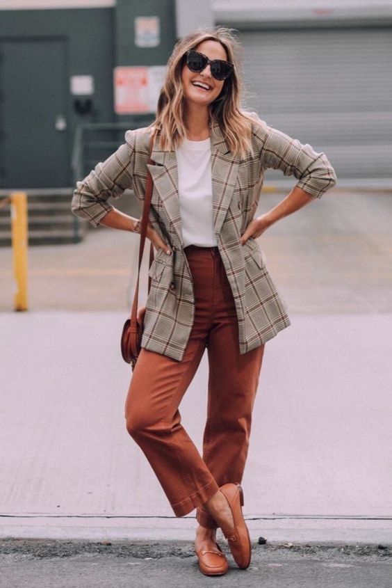 a white t-shirt, a grey oversized plaid blazer, rust-colored trousers, matching loafers and a bag