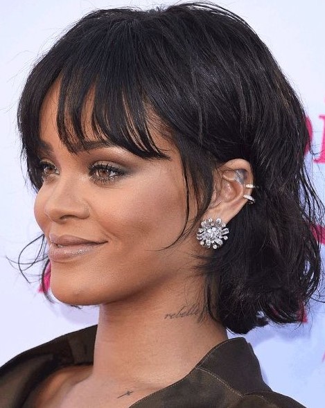 Rihanna rocking a black chin length bob with messy waves and wispy bottleneck bangs looks jaw dropping
