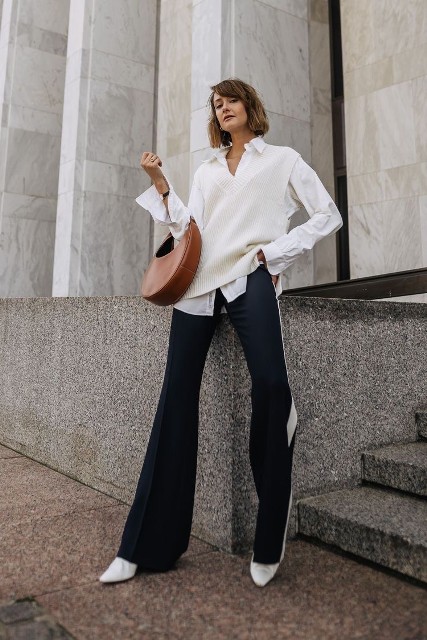 With brown leather bag, black and white flare pants and white heeled boots