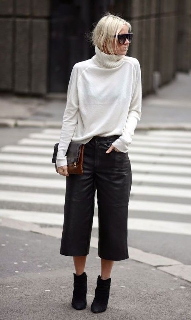 With oversized sunglasses, brown leather clutch and black suede ankle boots