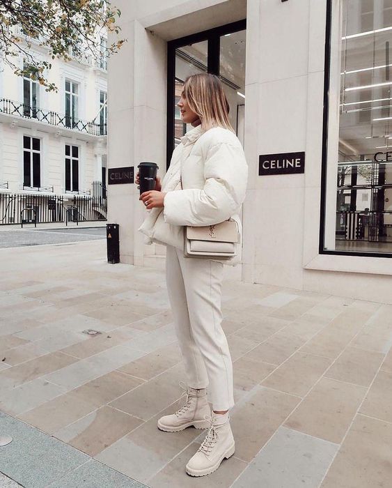 a beautiful neutral winter look with a cropped puffer jacket, white cropped trousers and neutral boots, a tan bag