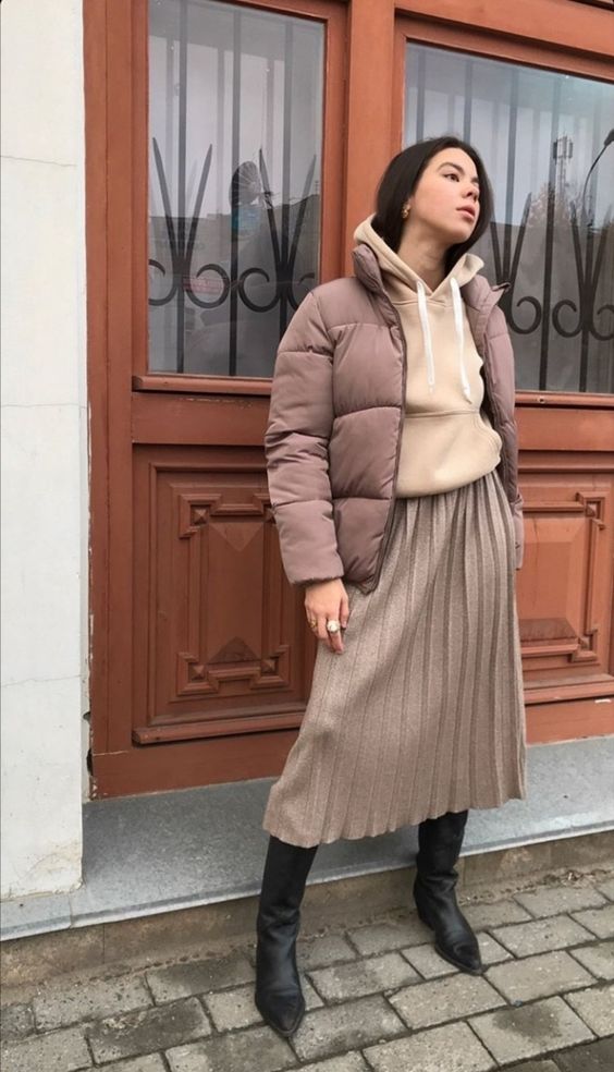 a beige hoodie, a greige pleated midi, black boots, a mauve cropped puffer jacket are great for winter