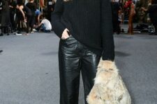 a black chunky knit sweater, black straight leg leather trousers, snakeskin print shoes and a faux fur jacket