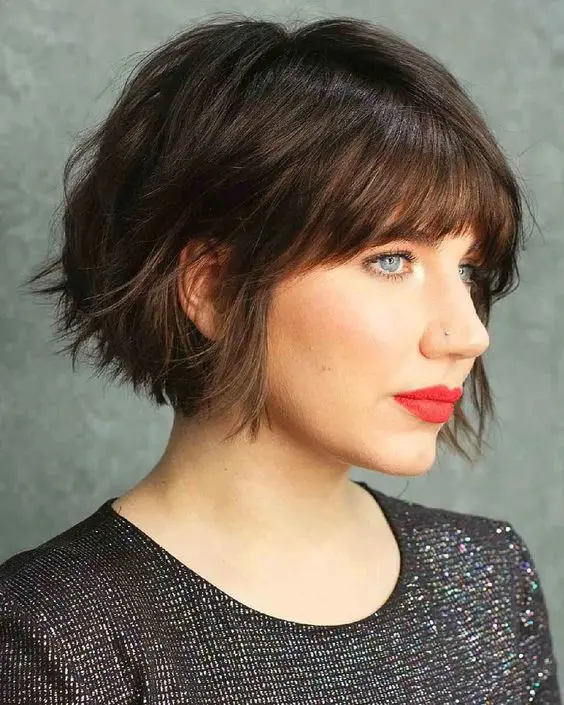 A black jaw length bob with a shaggy texture and a classic fringe is a stylish idea that looks effortless and cool