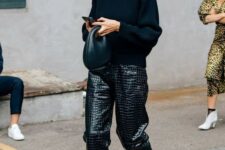 a black oversized sweater, black crocodile leather pants, white strappy shoes and a statement necklace