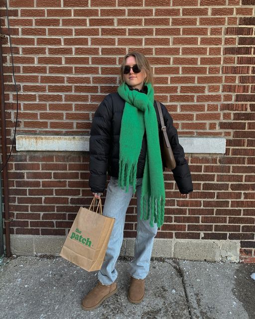 a black puffer jacket, bleached jeans, taupe ugg boots, a bold green scarf and a taupe bag are amazing for winter