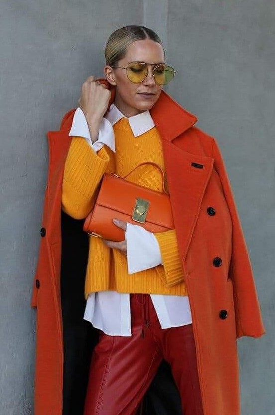 a bold fall work look with a white shirt, a yellow jumper, red leather pants, an orange coat and an orange bag