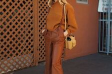 a bold fall work outfit with an orange turtleneck sweater, burnt orange leather pants, amber suede slides, a yellow bag