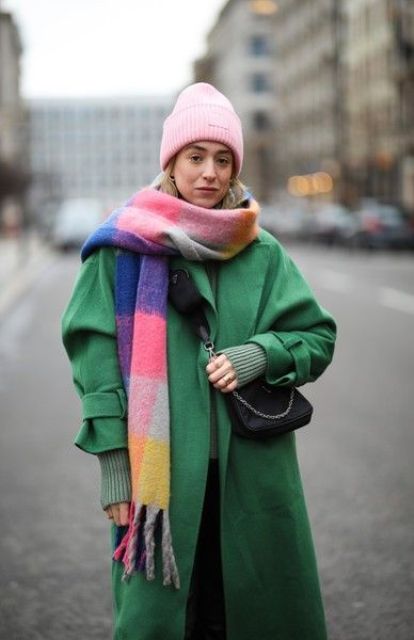 a bold winter look with a green coat and a sweater, a bold plaid scarf, a pink beanie and a black bag are great for winter