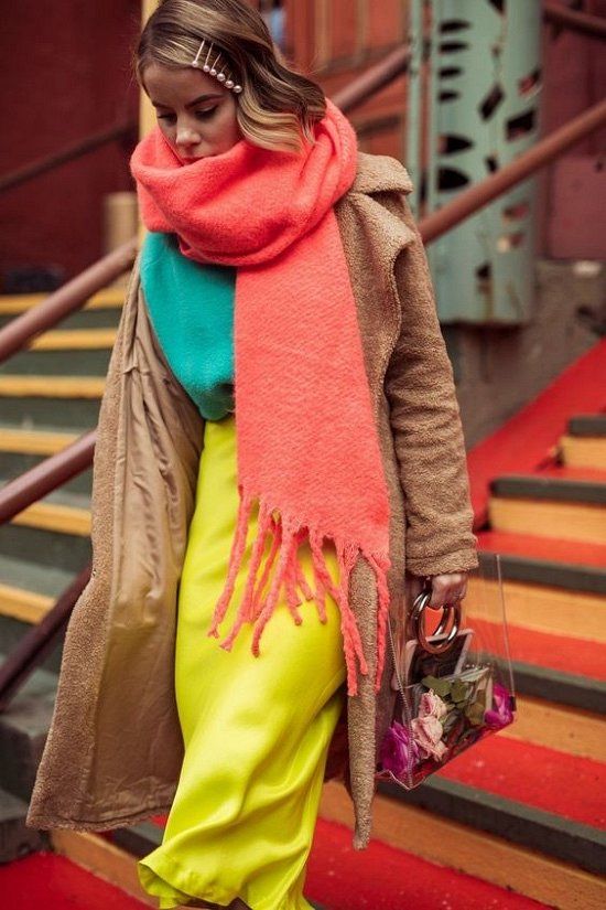 a bold winter look with a green sweater, a bold yellow skirt, a beige faux fur coat, a coral scarf and a clear bag