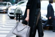 a business look with a black top, lack leather cropped pants, silver shoes, a black coat and a grey bag