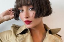 a chic dark brunette ear-length bob with a classic fringe and messy waves looks relaxed, cute and refined