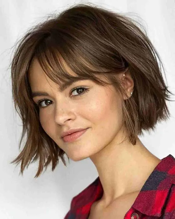 a cute wavy brunette bob with curtain bangs and a bit of messy texture is a great idea to rock right now