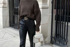 a dark brown sweater, black leather pants, a logo belt, white sneakers and a white bag for a classic look