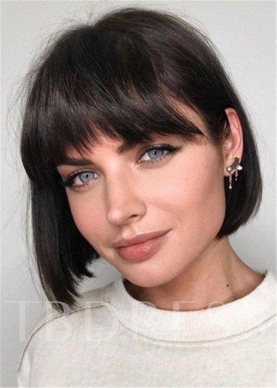 a dark brunette, almost black boy bob haircut with wavy outgrown bangs is a stylish idea to try right now