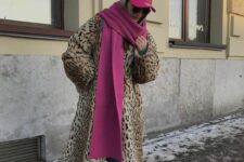 a faux leopard midi coat, blue jeans, brown ugg boots, a pink scarf and a pink cap for a comfy and bold winter look