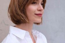 a ginger brunette choppy bob with wispy bangs and caramel balayage is a very stylish idea