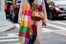 a lacquer pink leather trench, blue jeans, black boots, a colorful plaid scarf and an orange bag for a bold winter look