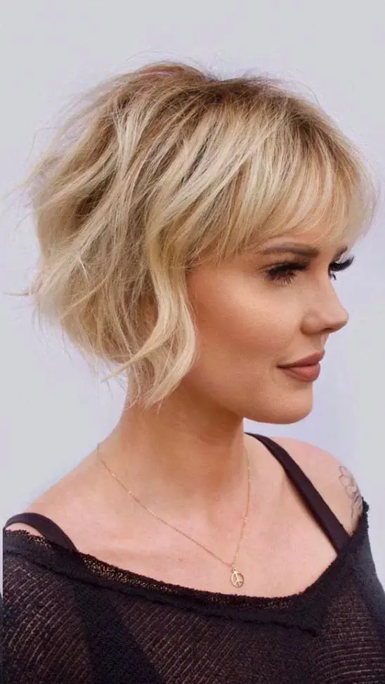 a lovely ear-length blonde bob with a classic fringe and messy waves plus a lot of volume is very chic