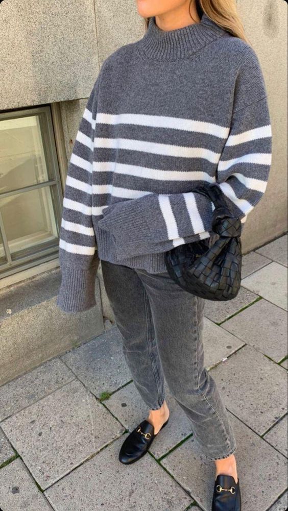 a monochromatic outfit with a grey Breton stripe sweater, grey jeans, black loafers and a black bag is wow